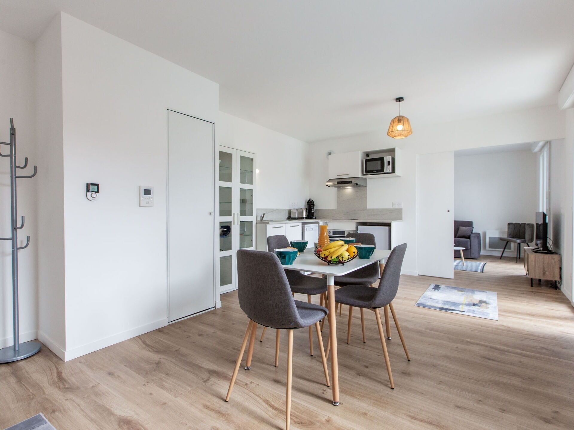 A modern apartment with a dining area, kitchen, and living space.