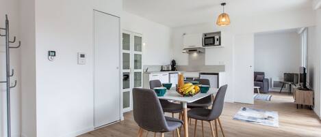 A modern apartment with a dining area, kitchen, and living space.