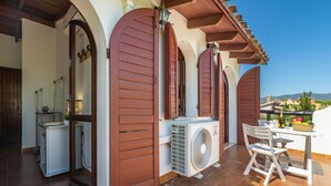 Eine Terrasse mit Tisch, Stühlen und einer Klimaanlage.