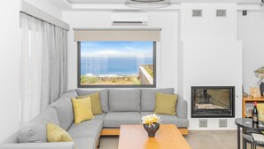 A modern living room with a grey sofa, a wooden coffee table, and a fireplace.