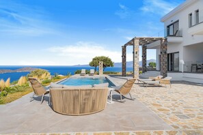 A pool area with lounge chairs and a pergola, overlooking a scenic view of the sea and mountains. - Elounda Sole Mare Villa (Elounda)