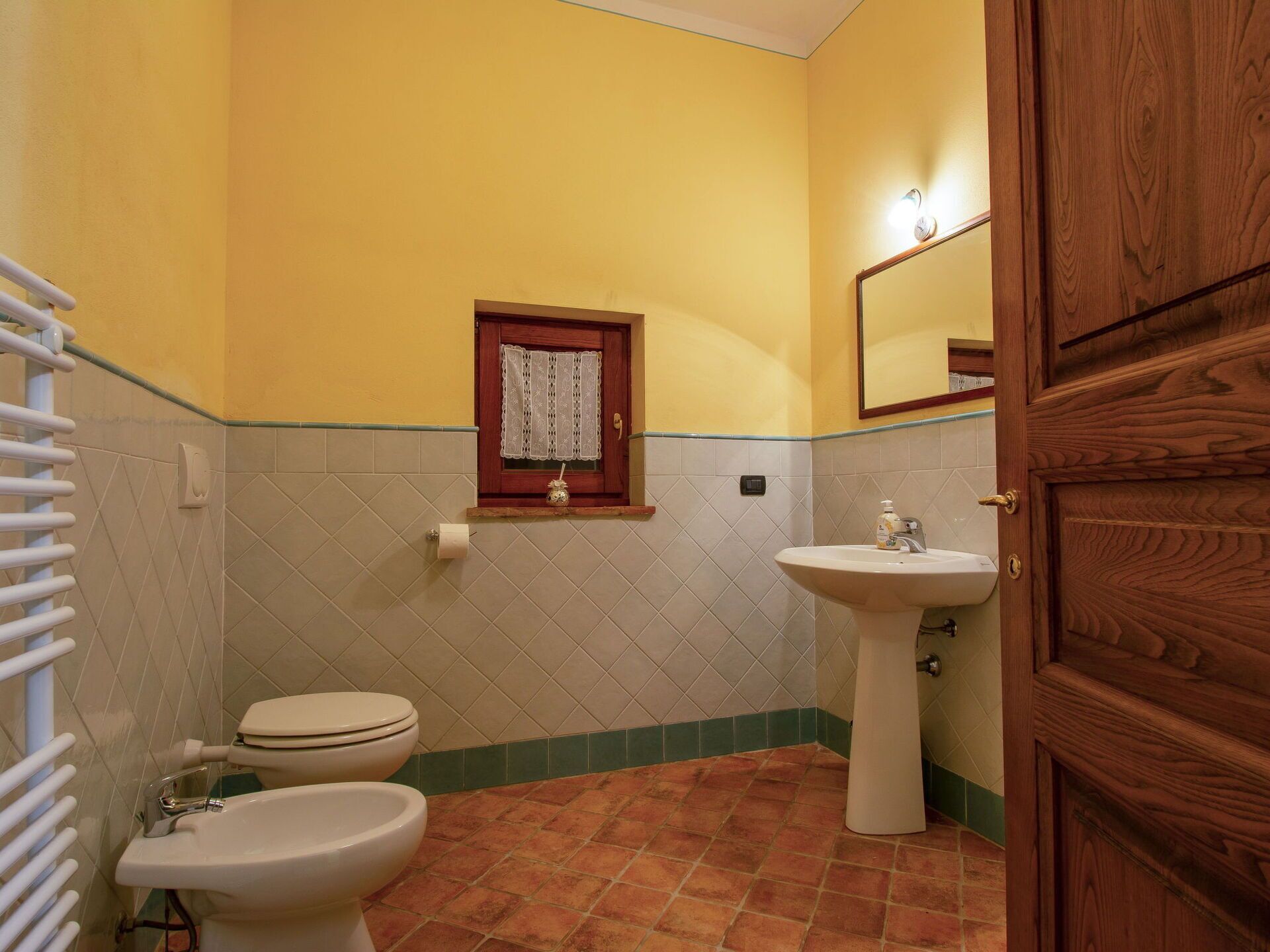 A bathroom with a toilet, bidet, and sink.