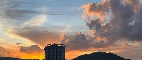 Un edificio alto con techo plano, rodeado por un paisaje montañoso.