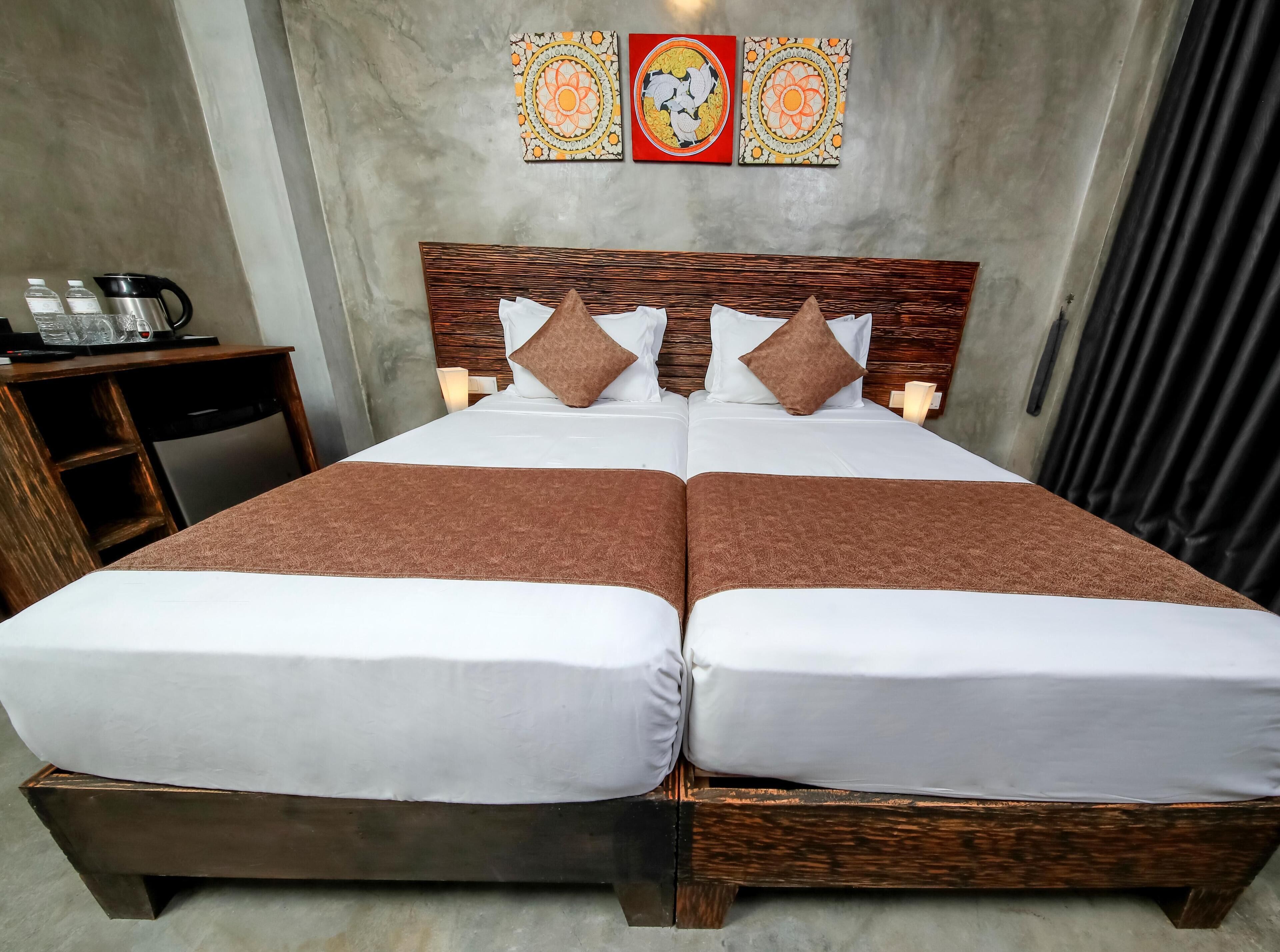A double bed with brown bedding, a wooden headboard, and two bedside tables with lamps.