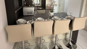 Eine moderne Küche mit Essbereich, inklusive Tisch für sechs Personen, Backofen und Mikrowelle.