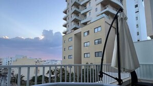 Un bain à remous avec vue sur un immeuble à plusieurs étages et un ciel dégagé.