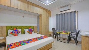 A bedroom with a bed, a desk, and a chair. - FabHotel Kas (Chhatrapati Sambhajinagar)