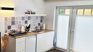 Une cuisine moderne avec un plan de travail en bois, des armoires blanches et un pare-feu en carreaux.