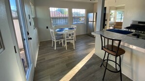 Une cuisine moderne avec un îlot central, des chaises blanches et une table à manger.