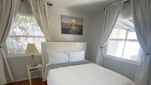 Une chambre à coucher avec un grand lit, une table de chevet, une lampe et un tableau au mur.