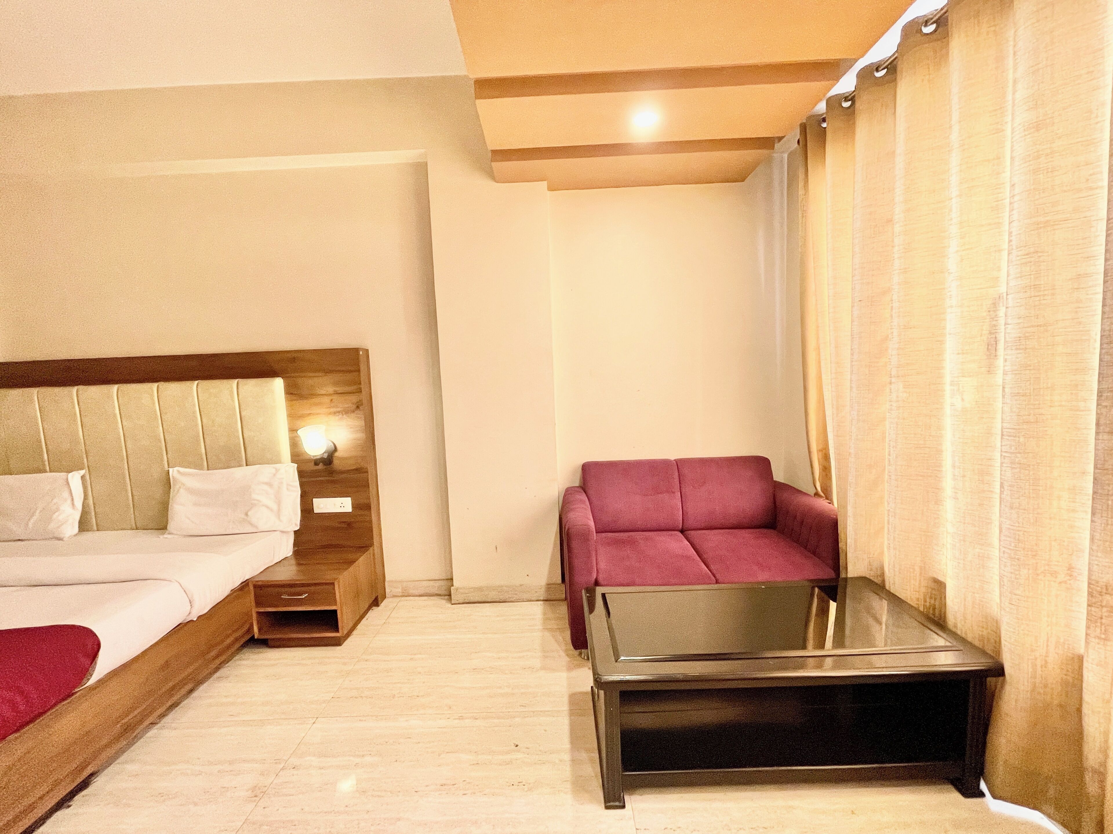 A hotel room with a bed, nightstand, chair, and a small table.
