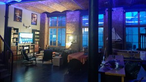A cozy living room with a fireplace, a bookshelf, and a large window. - Luxury loft in Lille/Tourcoing with sauna, spa, 4 guests, with parking (Tourcoing)