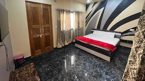 Une chambre à coucher avec un lit, une armoire en bois et un ventilateur de plafond.