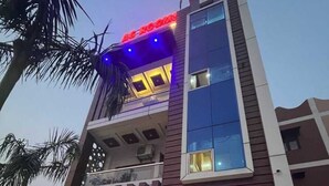 Un immeuble à plusieurs étages doté d’une façade moderne, de grandes fenêtres et d’un balcon éclairé de lumières bleues.