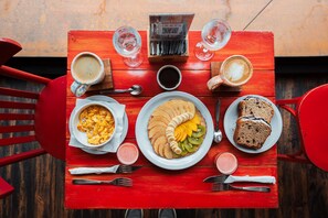 Guests can enjoy a meal at this outdoor dining setting, complete with a table, chairs, and a variety of food and beverages.