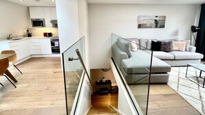 Un apartament modern amb cuina, zona de menjador i saló.