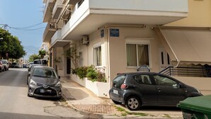 Un edificio residenziale a più piani con balconi, vista sulla strada e auto parcheggiate.