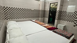 Habitación de hotel con una cama grande, ventilador de techo, aire acondicionado y diseño de pared a cuadros.