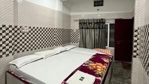 A bedroom with a bed, a ceiling fan, and a wardrobe. - Thakur Ji P. Guest House By GRB (Varanasi)