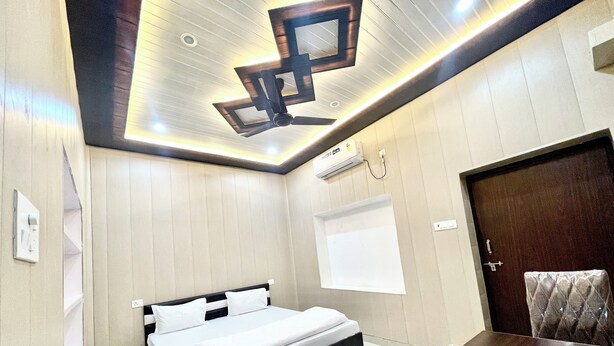 Una camera da letto moderna con un letto, un lampadario, un condizionatore d'aria e una porta.