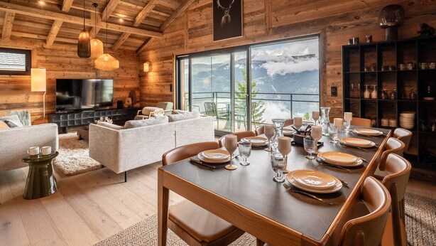 A wooden interior with a dining table set for six, a sofa, and a television. - Gorgeous 6-room chalet, jacuzzi and sauna, near slopes in La Plagne Montalbert (La Plagne Montalbert)