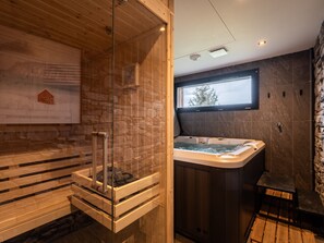 Une salle de bain moderne avec une douche à parois de verre, un meuble-lavabo en bois et un mur en pierre.
