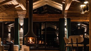 Een knus interieur met een open haard, houten balken en comfortabele zithoek.