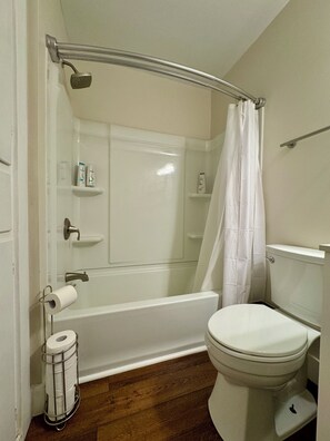 Ein Badezimmer mit Badewanne, Toilette und Duschvorhang.