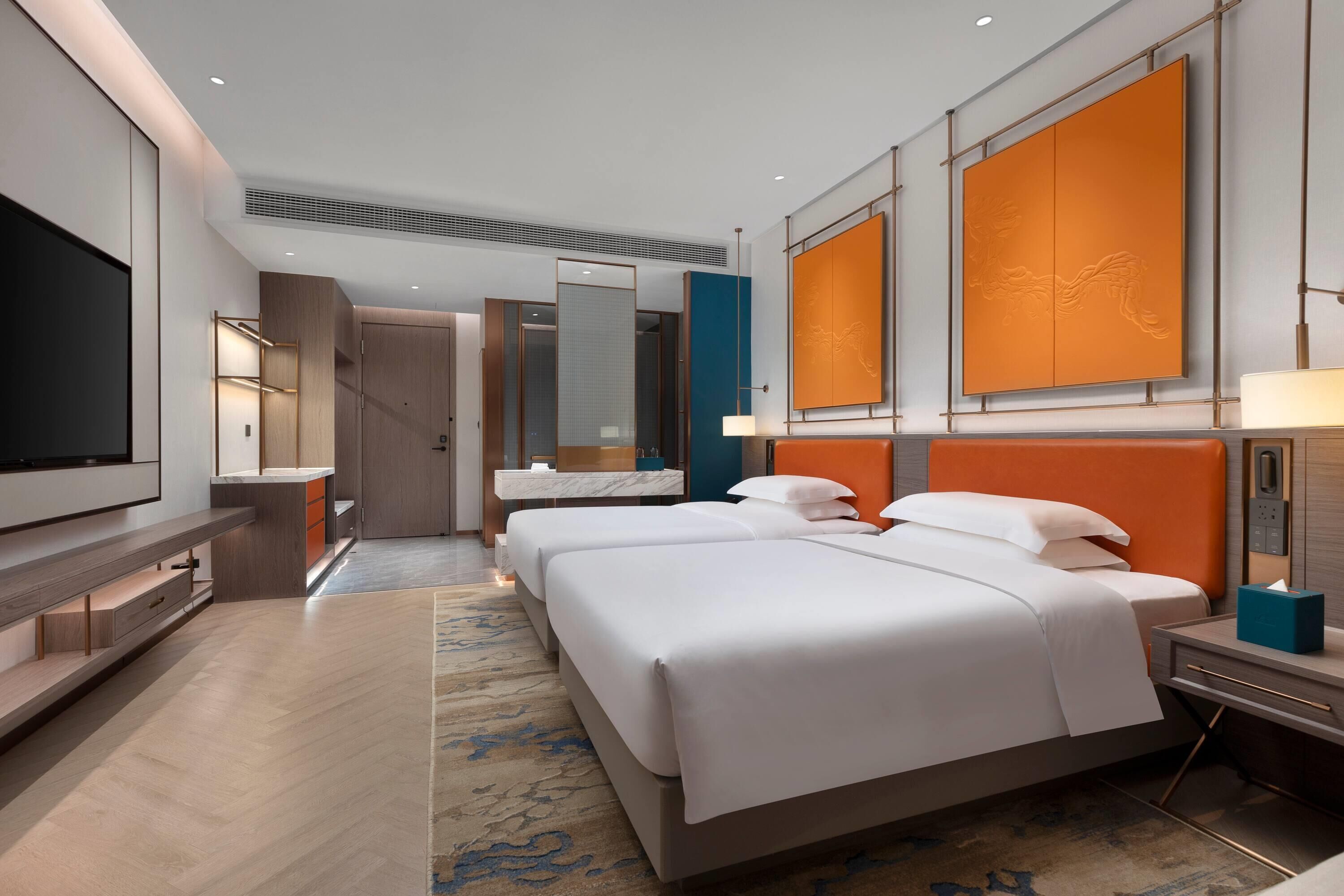 A hotel room with a large bed, a TV, a desk, and a bathroom.