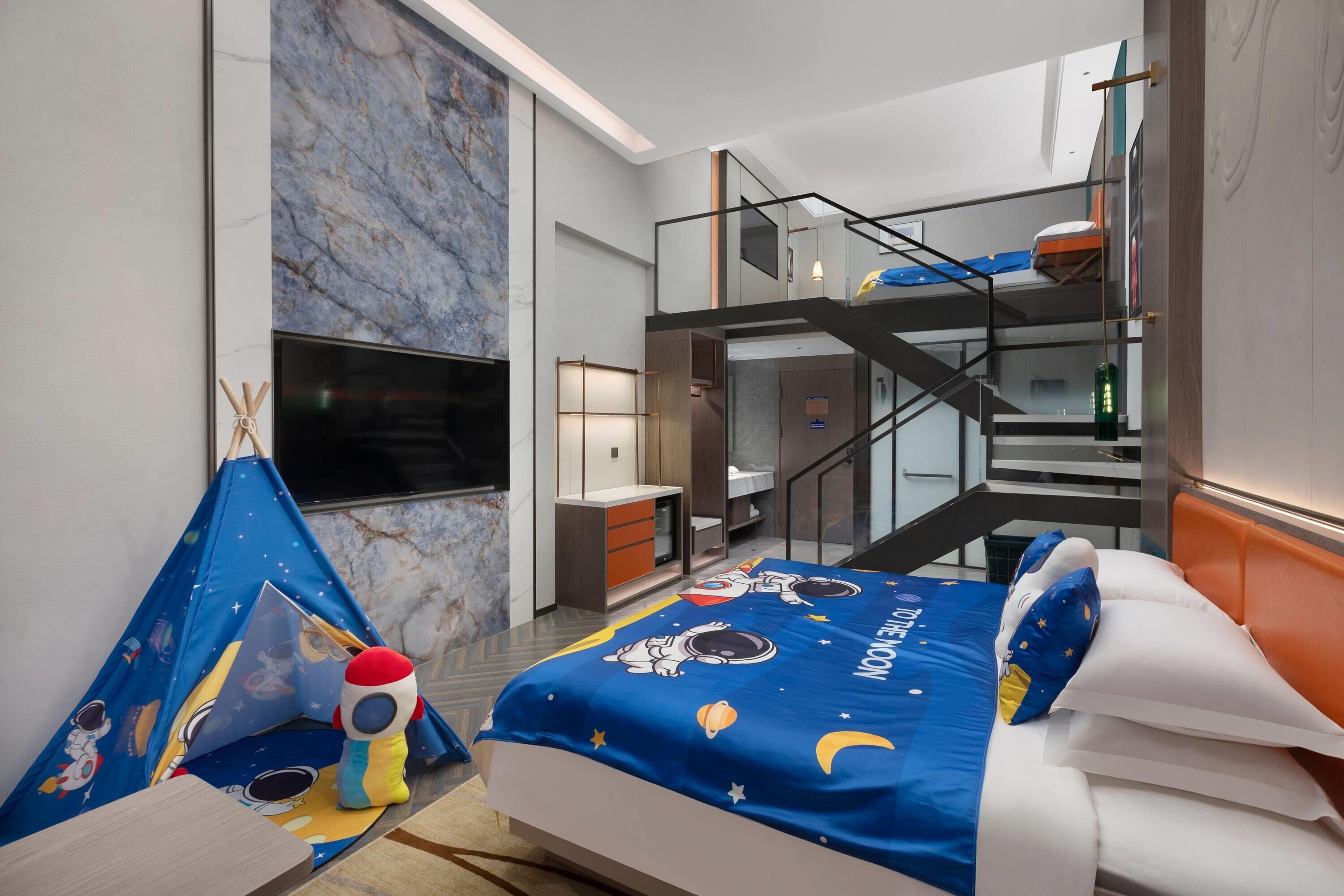 A hotel room with a bed, a TV, a balcony, and a staircase.