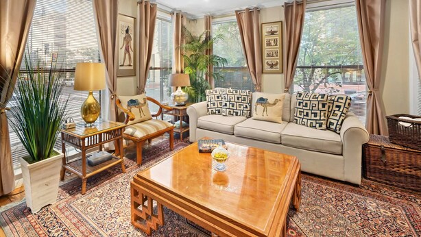 A spacious living room with a sofa, a wooden coffee table, and a patterned rug. - Washington, DC's Finest Address (Washington)