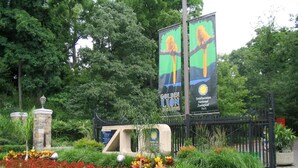 A garden area with a statue, a fountain, and a sign for the Smithsonian National Zoological Park. - Washington, DC's Finest Address (Washington)