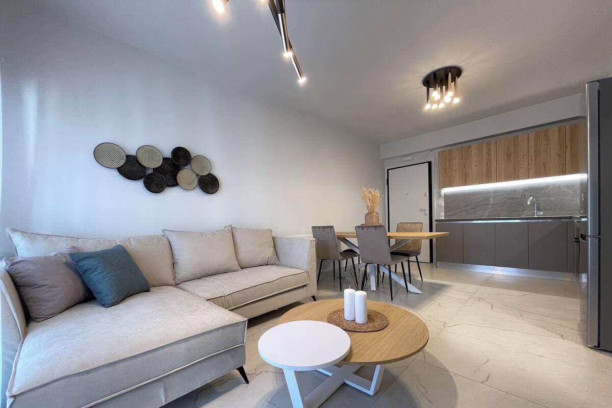 Una sala de estar moderna con un sofá, una mesa de centro y un comedor con sillas y una mesa.