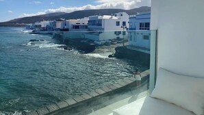 Un paese costiero con edifici bianchi, cielo sereno e mare calmo.