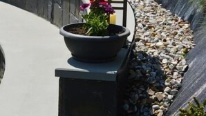 Un sentier sinueux, agrémenté d’une lanterne et d’un pot de fleurs.