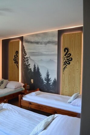A room with two wooden beds, a large wall mural of a mountain landscape, and decorative wooden panels with script. - Pokoje Gościnne Pienińska Parzenica (Czorsztyn)