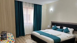 Een hotelkamer met een bed, een bureau en een stoel.