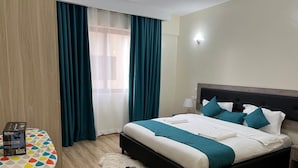 Et hotelværelse med seng, skrivebord og stol.