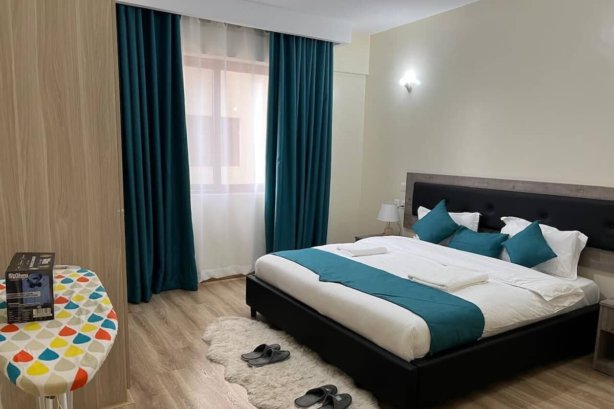 A hotel room with a bed, a desk, and a chair.