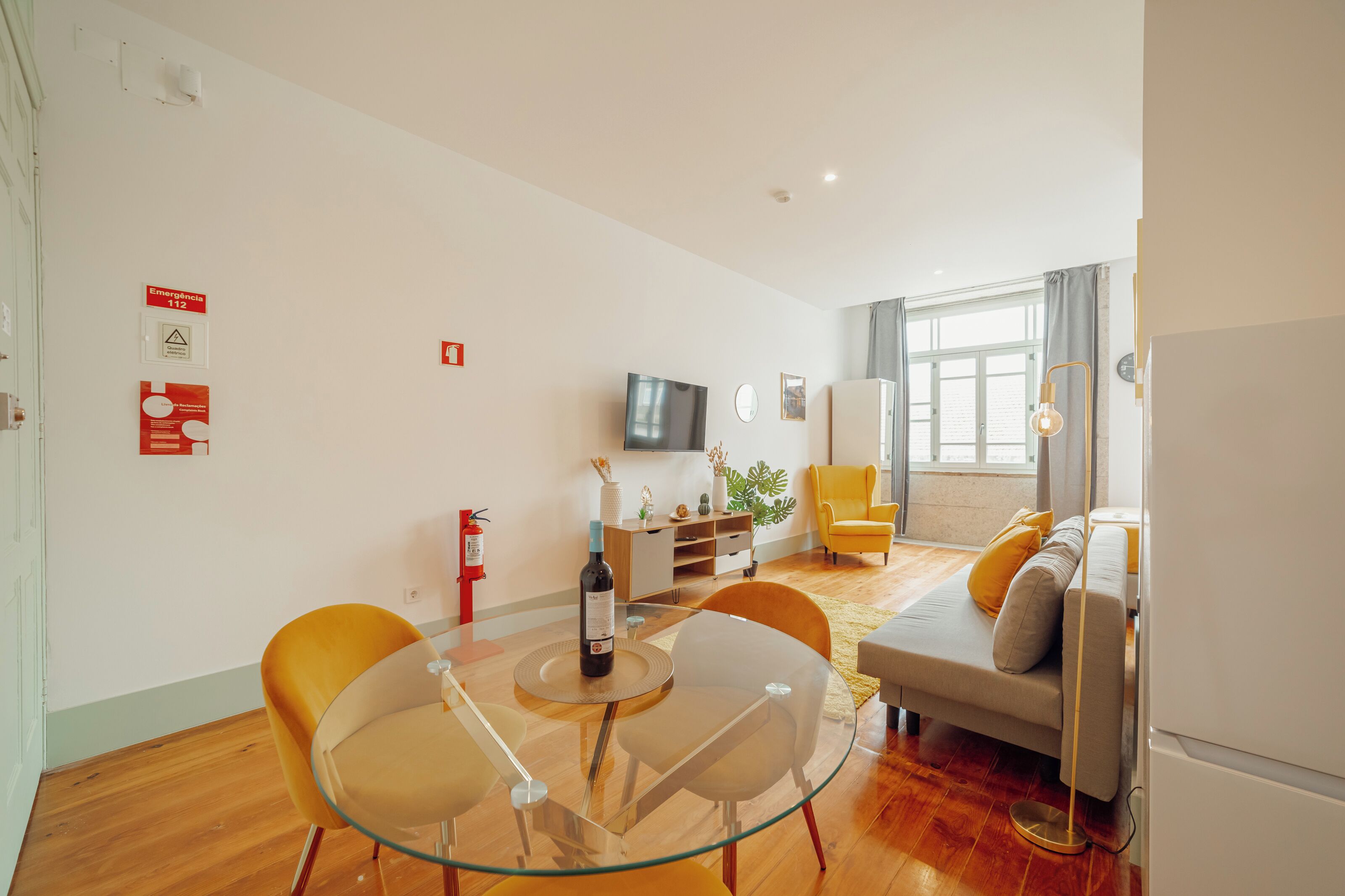 Ein modernes Wohnzimmer mit einem Glastisch, einer Couch und einem Fernseher.