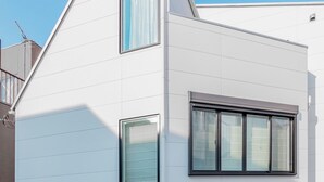 Un bâtiment moderne à deux étages, doté d’un toit plat, de grandes fenêtres et d’une façade blanche et épurée.