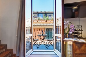 Un balcon avec une table et des chaises, un livre et un télescope.