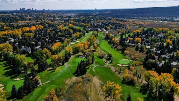 Vue aérienne d’un terrain de golf entouré de maisons.