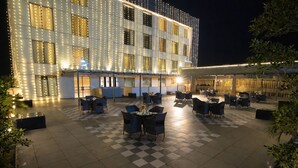 A hotel courtyard with outdoor seating and a checkered floor. - GREEN MOUNTAIN RESORT - Guna (Guna)