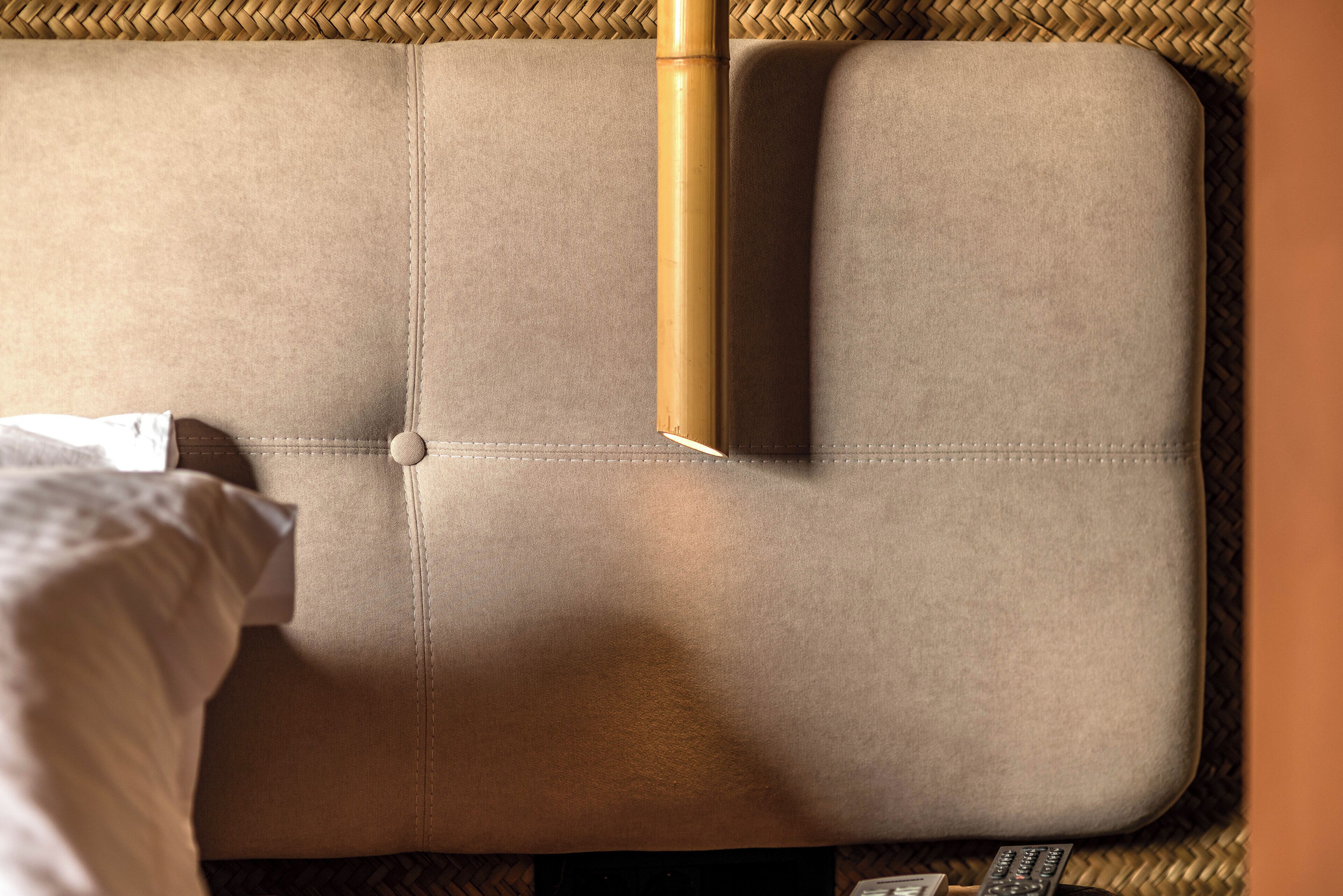 A sofa with a woven texture and a remote control on it.