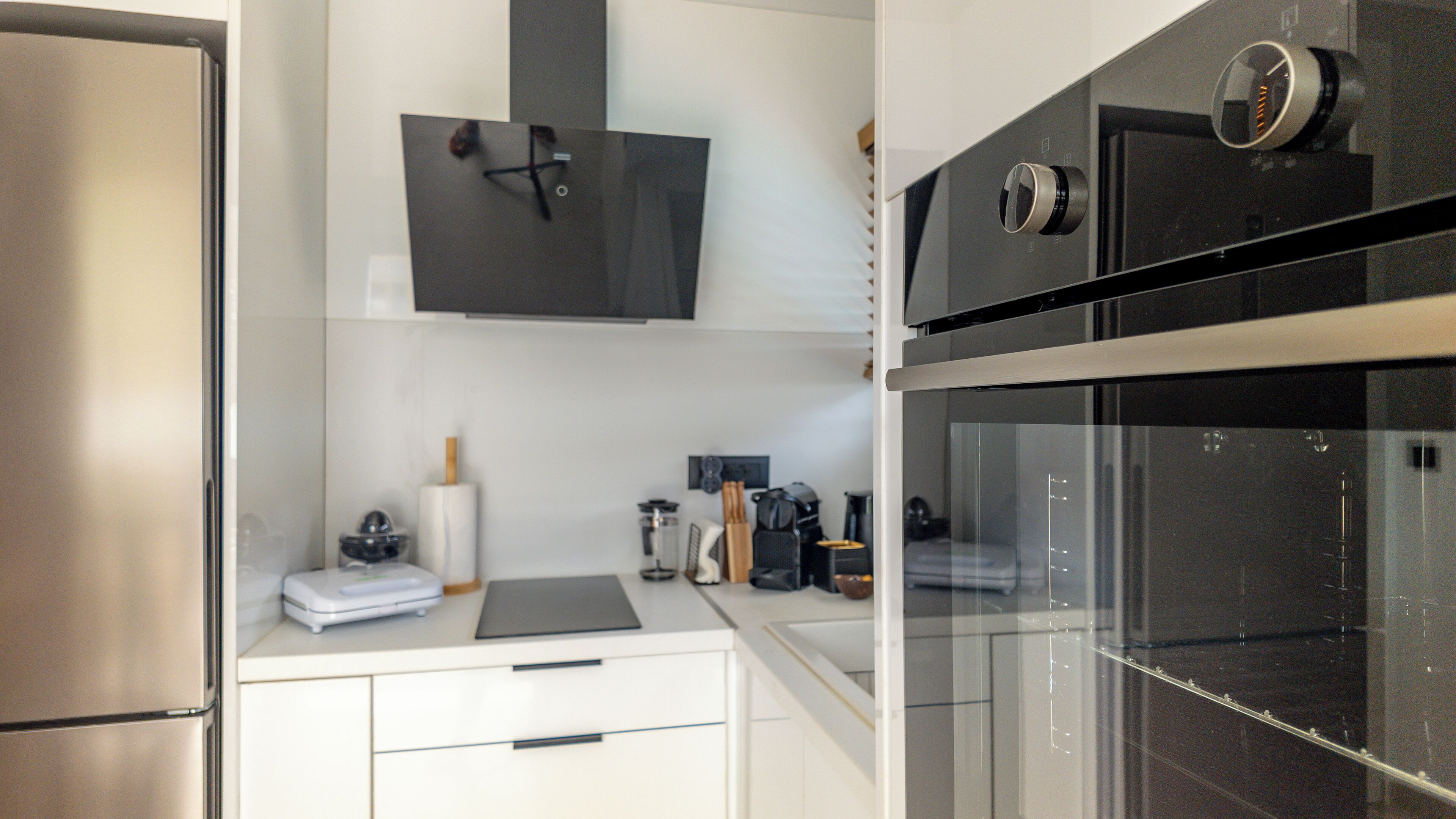 A modern kitchen with stainless steel appliances, a built-in oven, and a microwave.