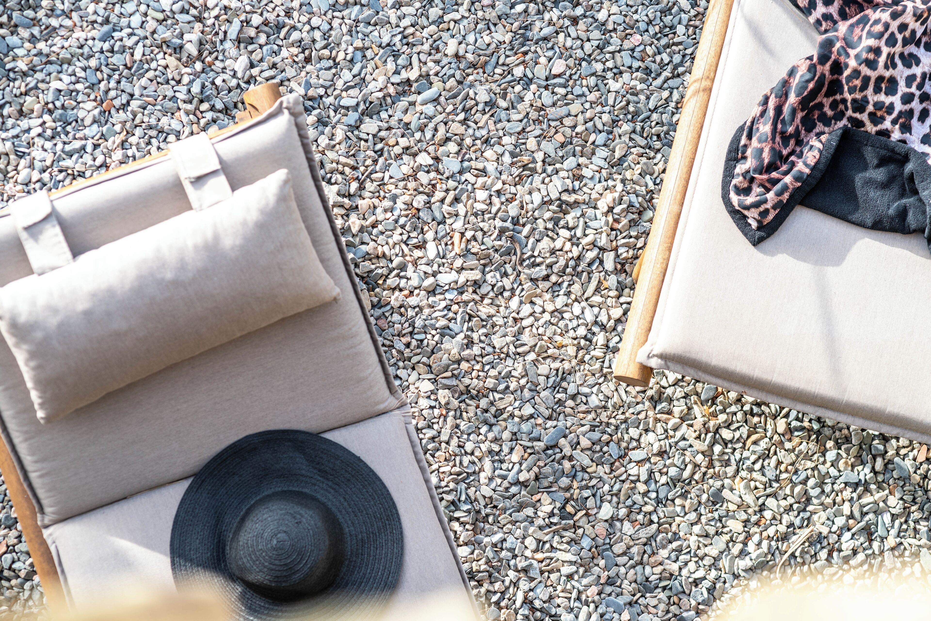 Une chaise longue avec un chapeau et une serviette à motifs léopard.
