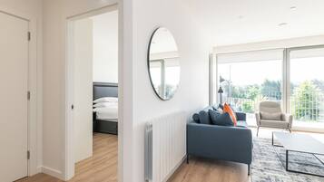 Apartamento Deluxe, balcón | Zona de estar | Una televisión