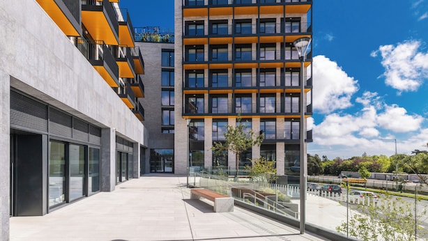 Un edificio moderno con varios pisos, ventanas grandes y techo plano.