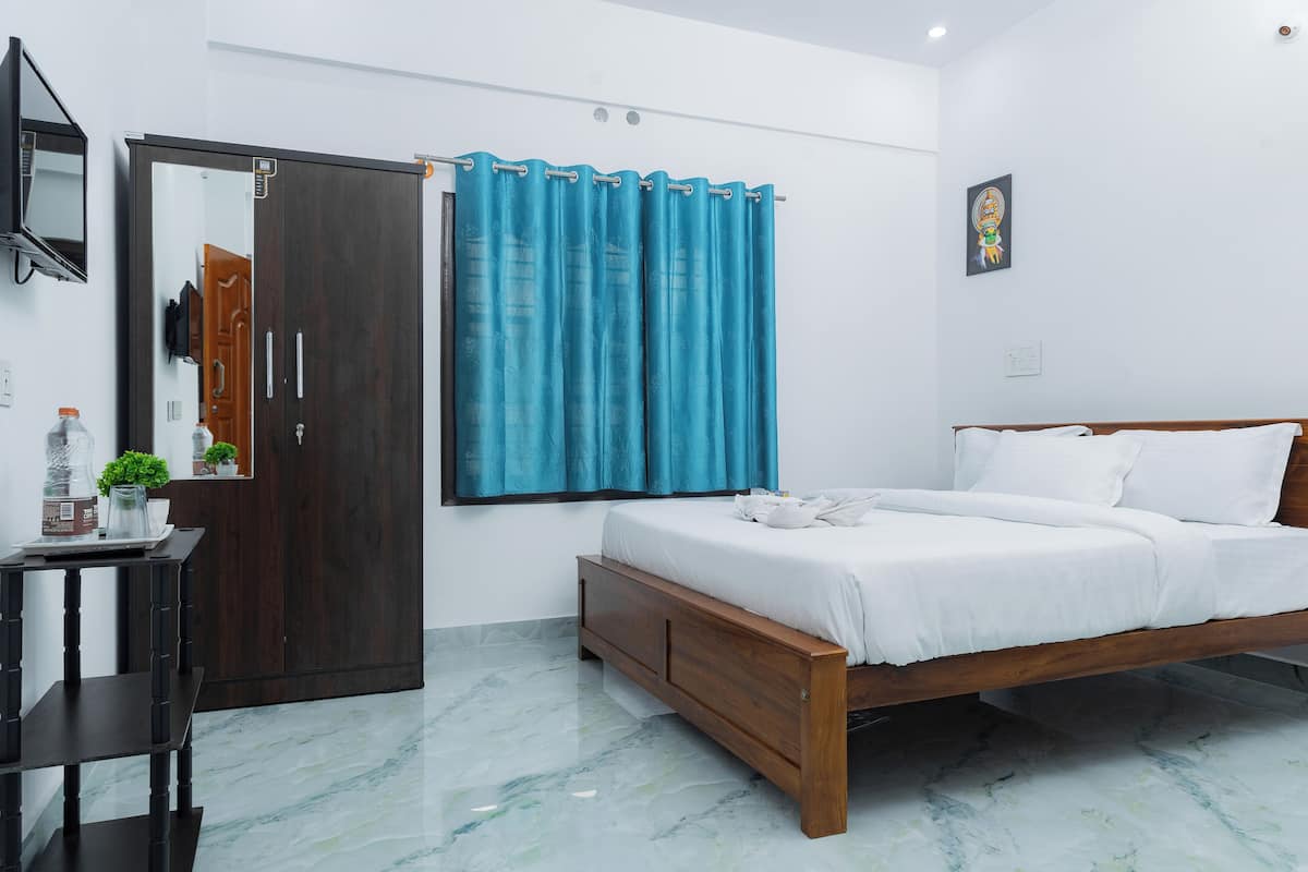 Quarto com cama de madeira, mesa de cabeceira, espelho, guarda-roupa e janela com cortinas.